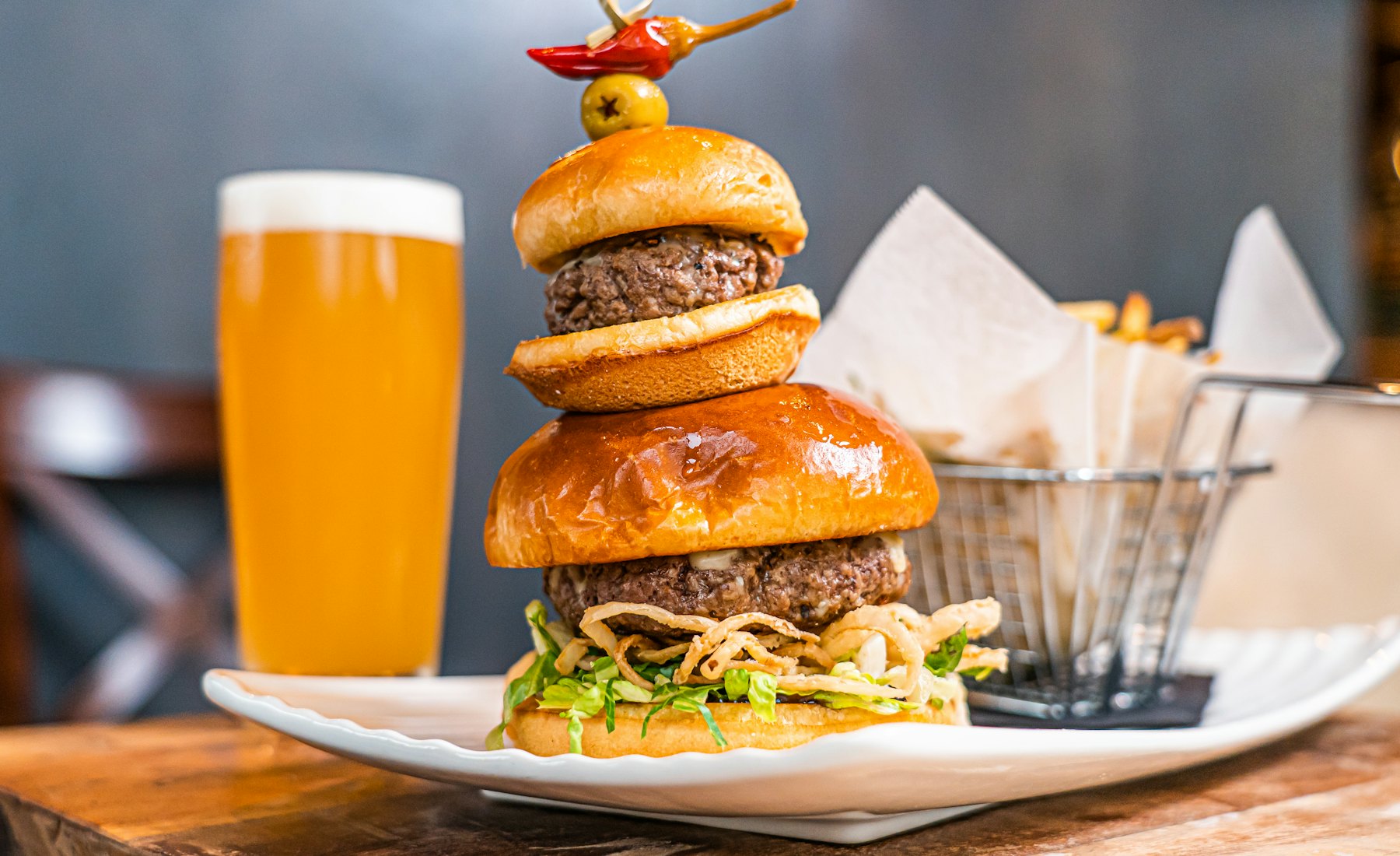 Hambúrguer alto com batata frita e chopp